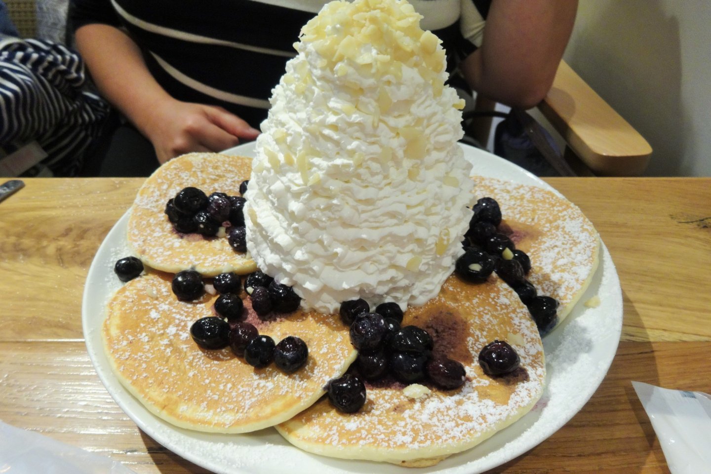 Blueberry pancakes piled high with whipped cream