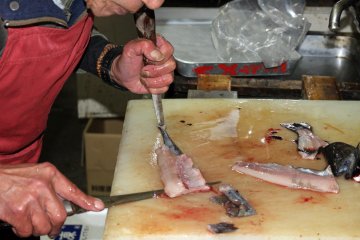 <p>The shop master skins and fillets the just-caught fish</p>