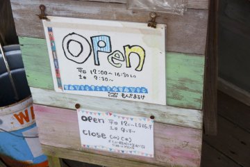 <p>ป้ายบอกเวลาเปิด-ปิดร้านก็ยังเป็นลายมือเด็กน่ารักๆ</p>
