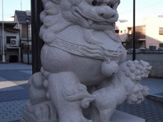 Salah satu patung singa penjaga di pintu gerbang, dengan seekor anak singa di kakinya
