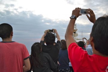 Passengers scramble to get a picture of the sunset