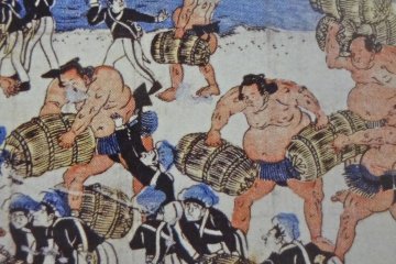 A contest of strength: Sumo wrestlers carry rice packs