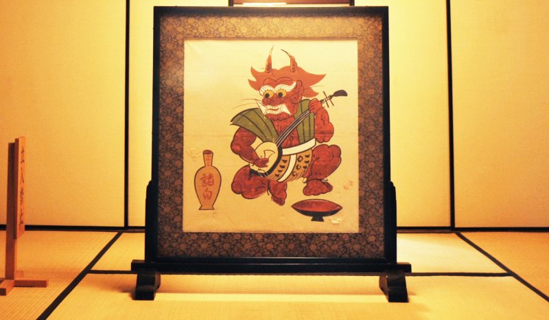 An otsu-e of a mythical goblin playing the shamisen and drinking sake
