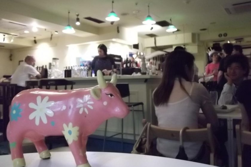 A pink cow watching over the action at the bar
