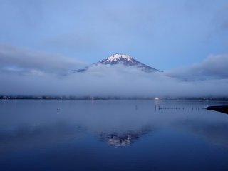 Mặt hồ phẳng lặng, phản chiếu ngọn núi trên mặt hồ.