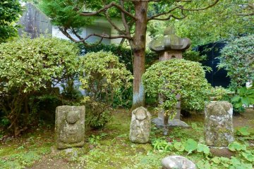 Old stone statues are scattered around the temple grounds