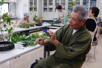 The Ikebana sensei giving a pupil advice on how to best present the flowers