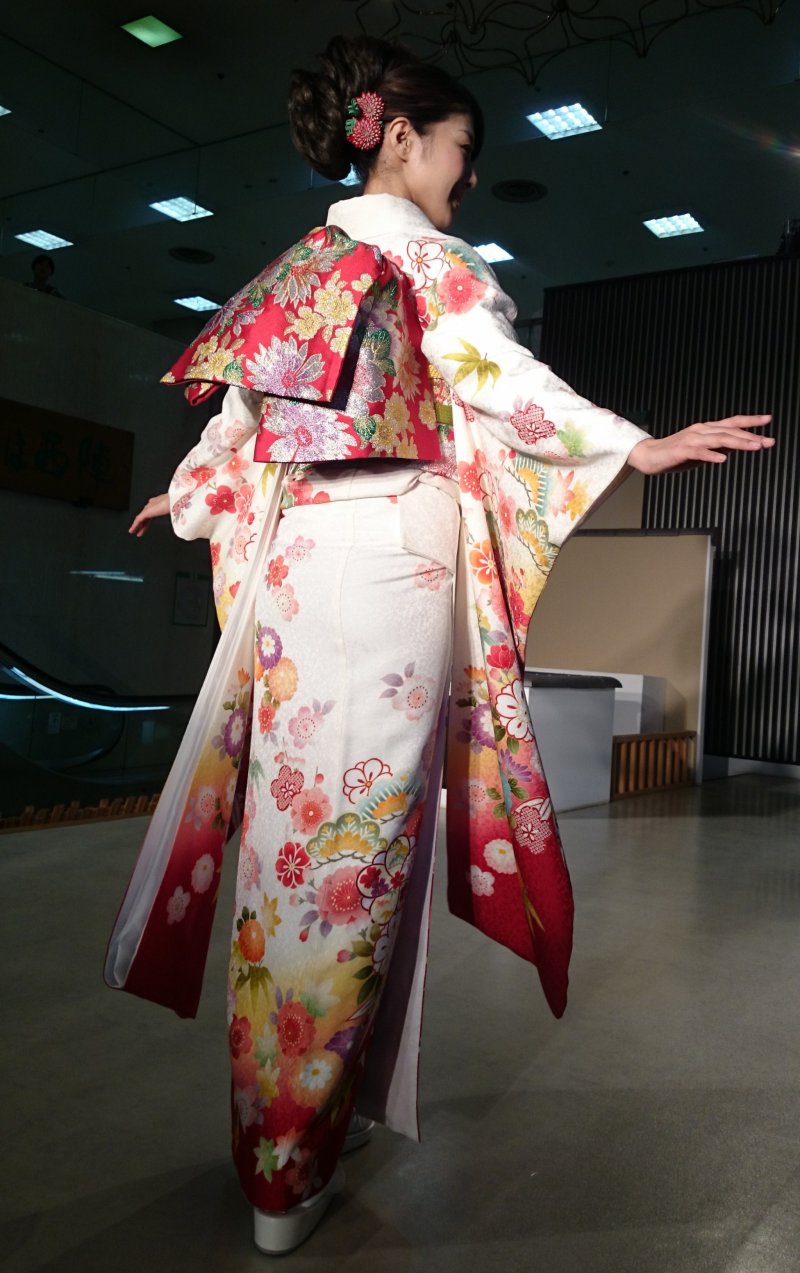 The floral design of the obi (tied at the back) distinctively recalls autumn colors