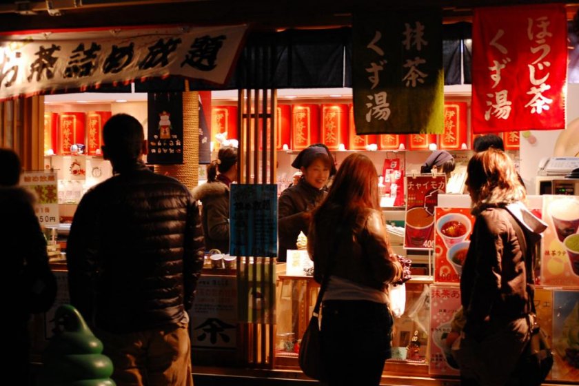 นักท่องเที่ยวที่ไปอิเสะ จิงกุกำลังผ่านซุ้มขายอาหารในถนนคนเดินใกล้ศาลเจ้า
