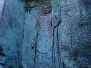 A tall relief image of Kannon carved into the wall