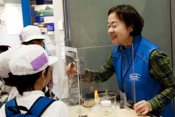 A museum operator shows an experiment
