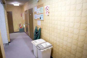 The corridor outside with rubbish bins