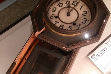 Haunting exhibit of a clock stopped at exactly 11:02.