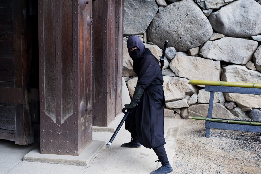 Một ninja đang chào đón khách du lịch ở cổng vào