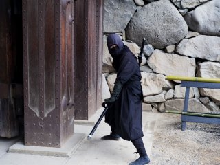 Seorang ninja menyambut para pengunjung di pintu masuk