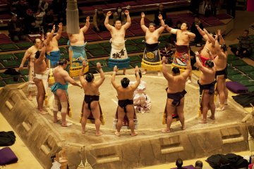 Makuuchi (top division) wrestlers form a circle wearing decorative 'kesho-mawashi' aprons