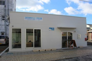Outside Ishinomaki Community & Info Center – the blue sign marks the water level from the 2011 tsunami