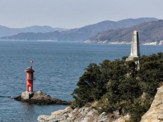 Ngọn hải đăng và tượng đài ở cuối mũi Suwazaki ở Yawatahama. Trên biển có ghi "Đừng trèo qua lan can". 