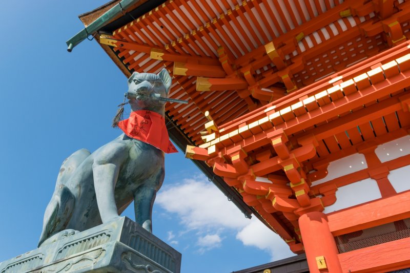 An effigy of Kitsune overlooking visitors to Fushimi Inari-taisha, Kyoto.