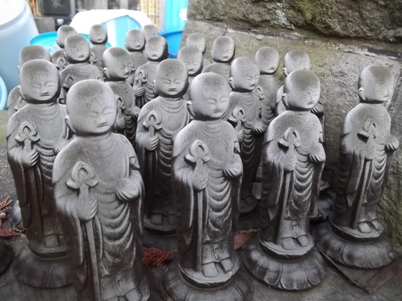 Lots of little statues attending around a larger one.