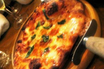Pizza on an earthy wood platter at the Volta Bar and Bistro in Osaka