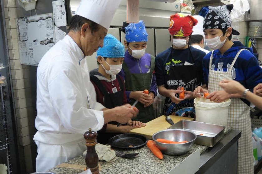 Students working with a Summit chef in the school kitchen