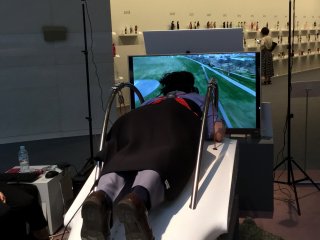 갤러리 전시회에서 비행 시뮬레이터를 즐기는 한 방문객