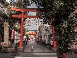  After walking along the main shopping street for several moments, be sure to look towards the left, along the side-streets where you will see this distinctive red ‘tori’ or gate. This gate marks the entrance to Anamori-Inari Shrine 