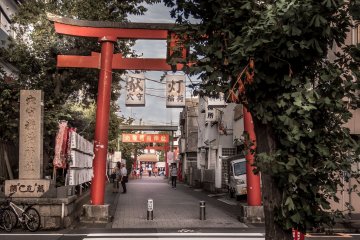  After walking along the main shopping street for several moments, be sure to look towards the left, along the side-streets where you will see this distinctive red ‘tori’ or gate. This gate marks the entrance to Anamori-Inari Shrine 