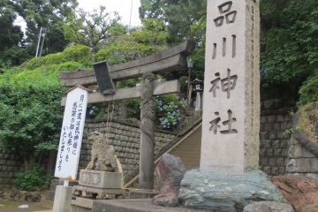 Shinagawa Shrine stone tablet and a sign encouraging people to come once a month