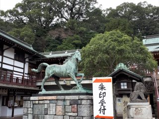 Seibo Kitamura, famous for Nagasaki's Peace Park Statue, created this vibrant horse statue in commemoration of the 60th anniversary of Emperor Hirohito's accession in 1985. Note the completely non-related signage directing visitors to the desk selling shrine seal stamps, a popular shrine souvenir.