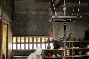 A servant prepares food in the grounds of Yuzuki Castle