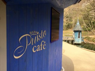 Café Puisto và bên ngoài tường gỗ xanh có ghi "Snufkin!"