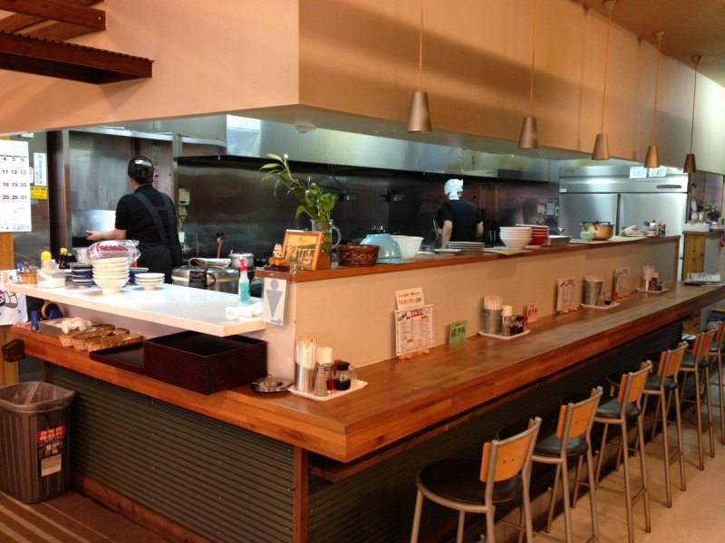 <p>The kitchen is lined with bar stools allowing patrons to see their orders prepared right before their eyes</p>