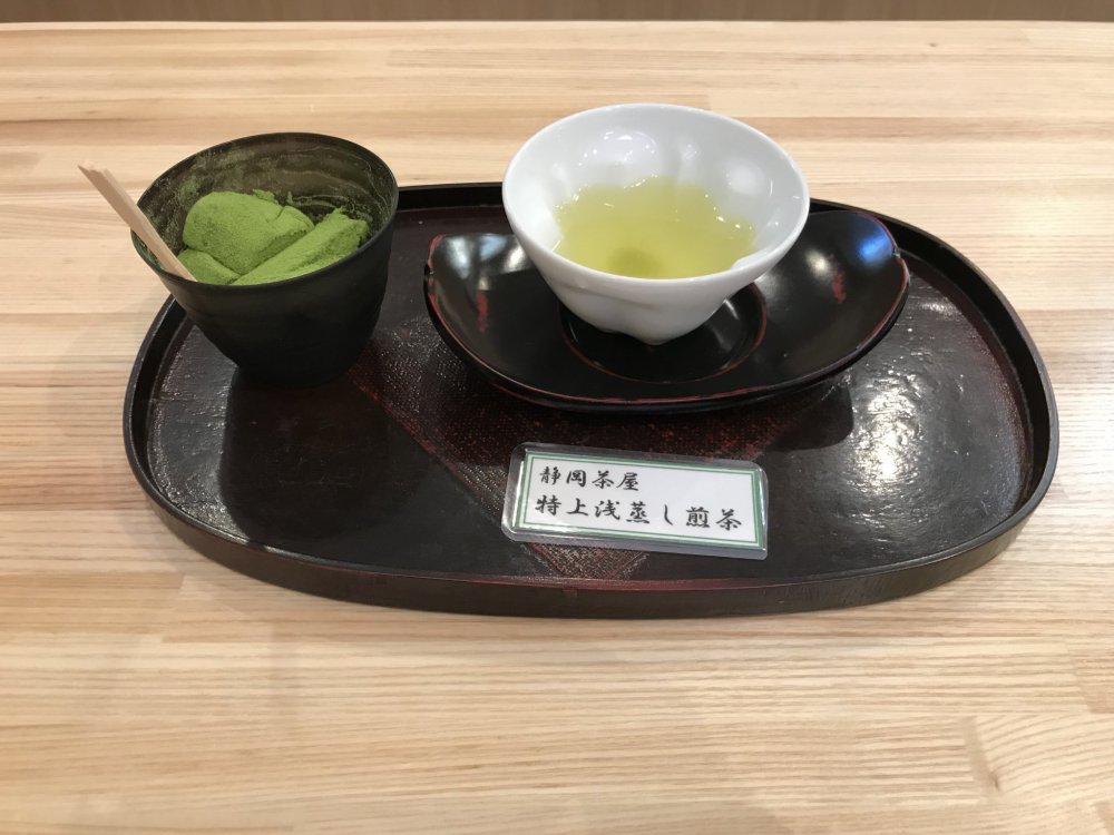 Samples of green tea and warabi mochi dusted in matcha powder 