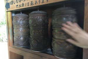 These are called 'mani-guruma'. Sutras are kept inside. Turning them is equivalent to reading a verse