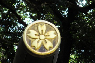 Эмблема в виде круга с изображением цветка сакуры
