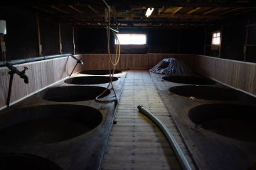 Soy sauce being fermented in traditional vats