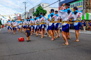 Traditional dancers parade down the street