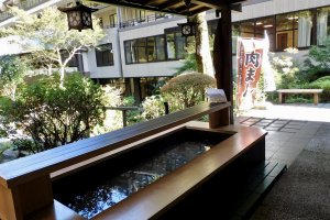 Visitors can soak their feet in an onsen foot bath while enjoying a drink in the garden.