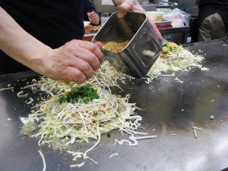 Окономияки в стиле Хиросимы. Обжариваем капусту, ростки, лапшу, добавляем зелёный лук и кукурузу