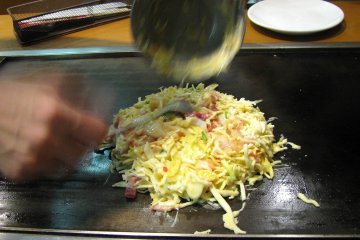 В смесь капусты, лапши, мелко порезанного бекона добавляем сырое яйцо (его предварительно взбалтываем)