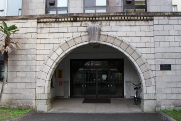 The building's exterior still shows the original architecture, the highlight being the sturdy stone arch.