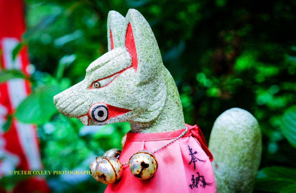 A stone fox with bib and scroll