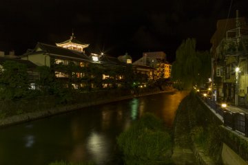 The historic K's Onsen lights up the river at night