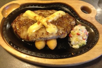 <p>Hamburger Steak set with cheese accompanied by a pair of french fried whipped potatoes and vegetables in a cream sauce</p>