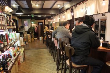 <p>In the back of the store is a counter for sake testing. Not only sake, but &nbsp;genuine&nbsp;Kyoto style appetizers&nbsp;such as pickled vegetables and boiled tofu are served</p>