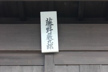 <p>A period nameplate hangs on the outside gate</p>