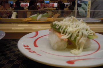 <p>I am a big fan of avocado with sushi. I got hooked in Canada,&nbsp;where the combination is common.&nbsp;I think this is peeled cooked prawn topped with avocado sauce and mayonnaise. My other favorites&nbsp;were devoured too quickly for me to remember to take a photo; if you like nuts, try the sushi&nbsp;topped with nuts</p>