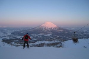 A skier decending with Mt. Yotei in the background